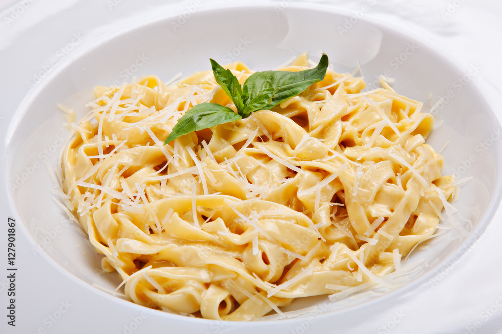Close-up italian pasta plate with grated parmesan cheese and bas Close-up italian pasta plate with grated parmesan cheese and bas