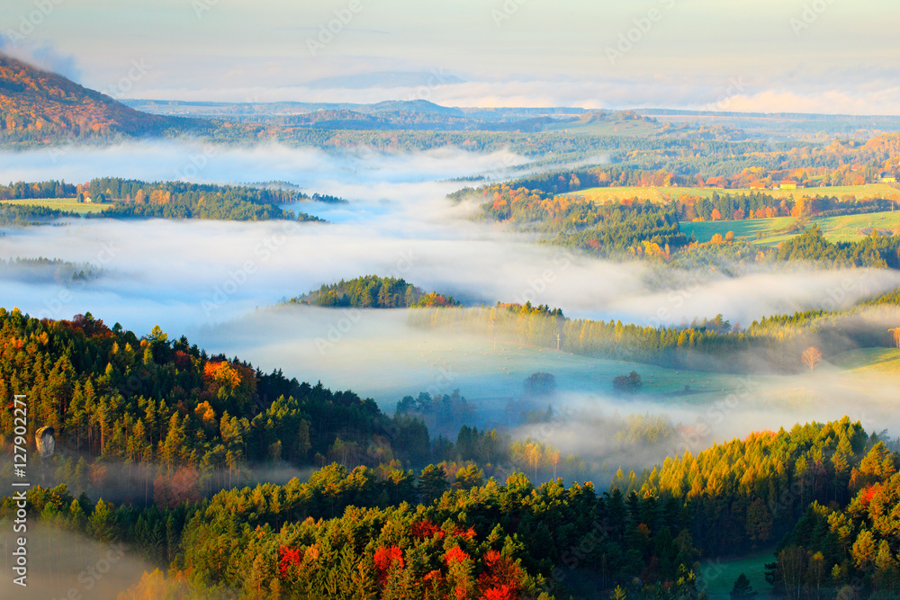 Czech typical autumn landscape. Hills and villages with foggy morning. Morning fall valley of Bohemian Switzerland park. Hills with fog, landscape of Czech Republic, Ceske Svycarsko, wild Europe.