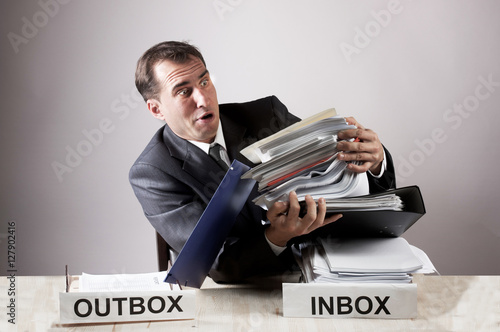 Stressed office worker with a paper stack