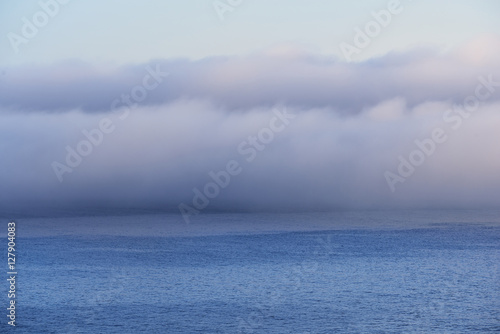 Low morning fog over ocean waves in Brittany, France
