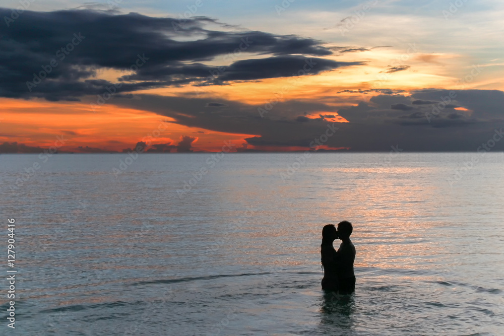 pareja besandose en el mar Stock Photo | Adobe Stock