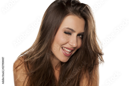 Young happy woman winking on a white background