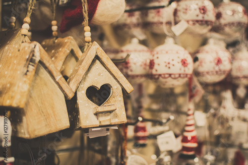 Hanging Christmas decoration in the shop with tags, with blurred baubles on the back, selective focus