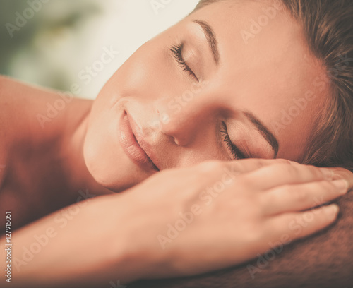 Beautiful young woman having massage in a spa salon