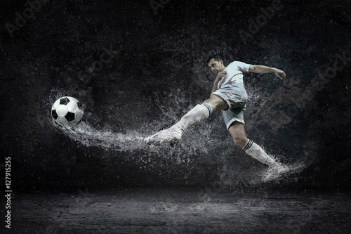 Splash of drops around football player under water