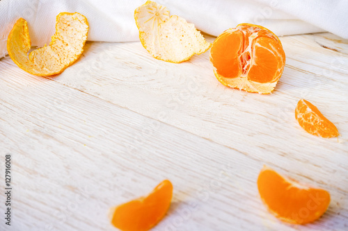 peeled tangerine on white boards
