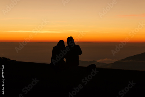 Silhouette couple lovers watching sunrise