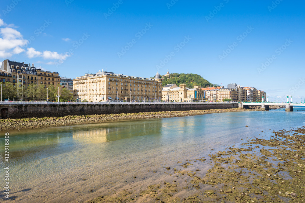 View over the river Urumea to the Victoria Eugenia Theater, a neoplateresque building, a special Spanish architecture, in Donostia San Sebastian. The river is passing through the very nice Basque city