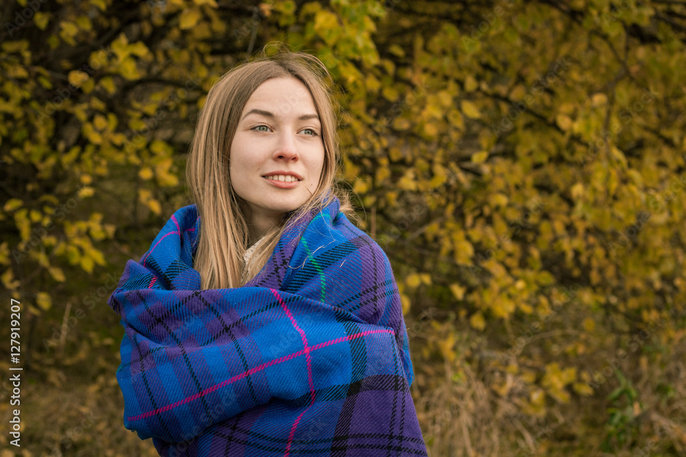 young woman in autumn garden covered in plaid young woman in autumn garden covered in plaid