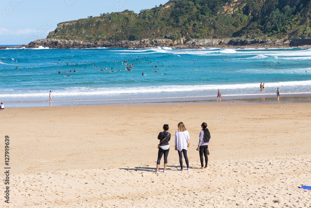 Surfer do water sport, people relax at the beach La Zurriola in Donostia San Sebastian. The beach is situated at the district Gros of San Sebastian. The beach is famous for surfing,sports and relaxing