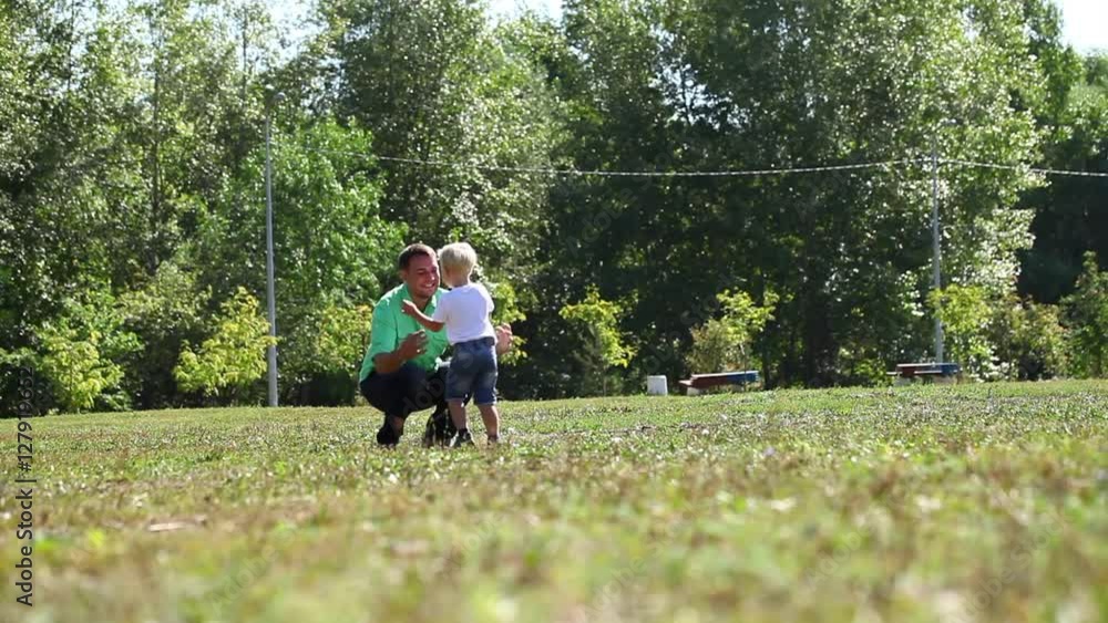 Young father and son walking in the summer park Young father and son walking in the summer park