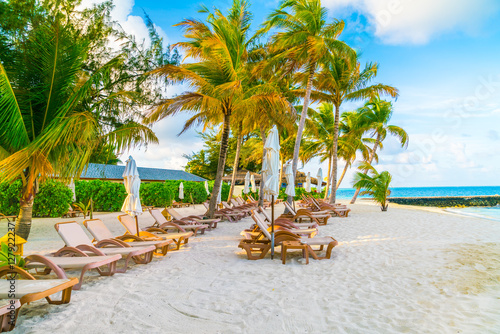 Beach chairs with umbrella at Maldives island  white sandy beach