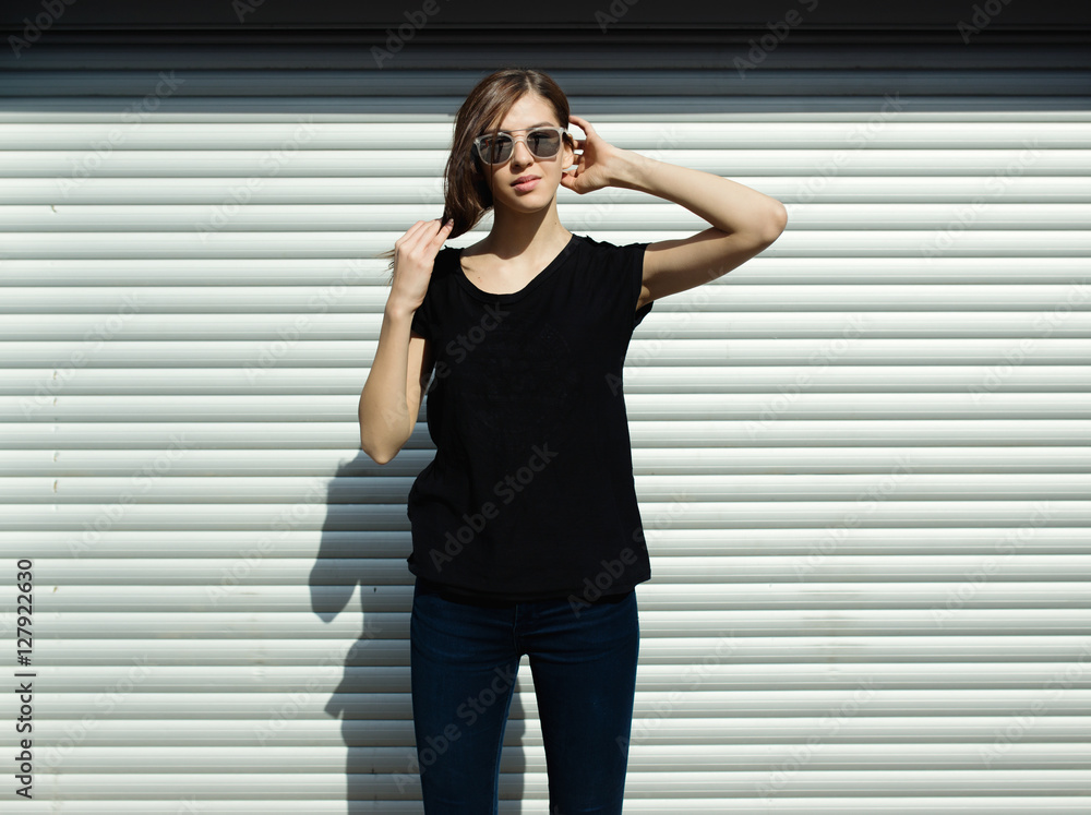 Portrait of girl in rock black style, standing outdoors in the city against the silver metal urban wall Portrait of girl in rock black style, standing outdoors in the city against the silver metal urban wall