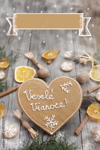 Christmas heart shaped gingerbread background. Winter holidays atmosphere. Snoflakes. Hand drawn ribbon for copy.Perfect for greeting cards, flyers, etc.Written in slovak