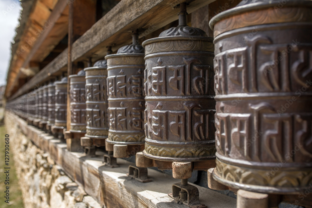 Buddhist prayer mani wall with prayer wheels in nepalese village on the Annapurna circuit trekking route, Nepal Buddhist prayer mani wall with prayer wheels in nepalese village on the Annapurna circuit trekking route, Nepal