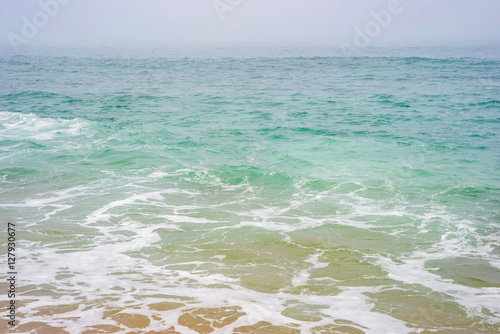 Sea ocean water wave foam sand beach horizon sky storm fog mist aqua cyan turquoise texture background
