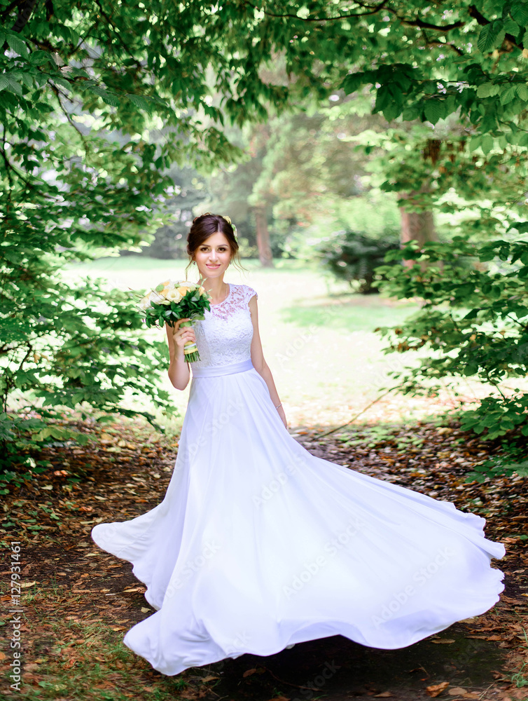 young beautiful bride in a white dress standing alone outdoors young beautiful bride in a white dress standing alone outdoors