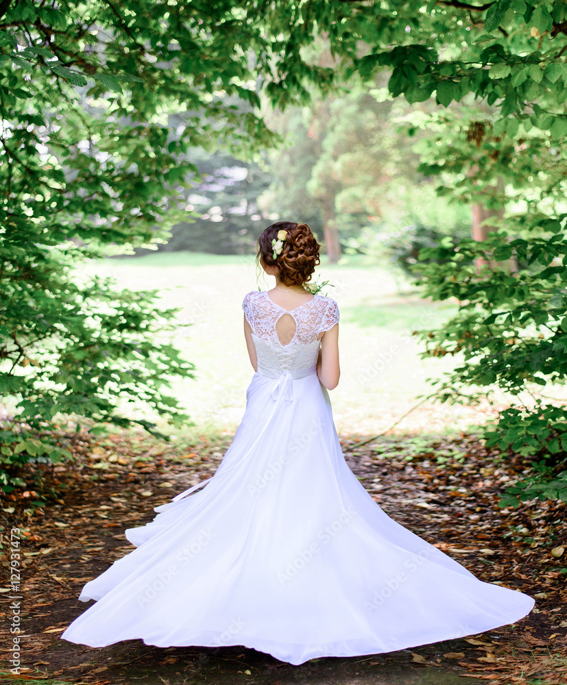 young beautiful bride in a white dress standing alone outdoors young beautiful bride in a white dress standing alone outdoors