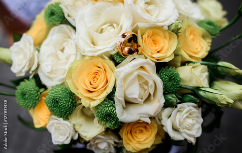 gold rings lie on a beautiful bunch of flowers