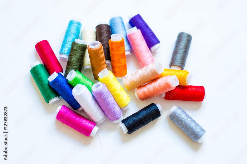 multicolored spools of thread on white background multicolored spools of thread on white background