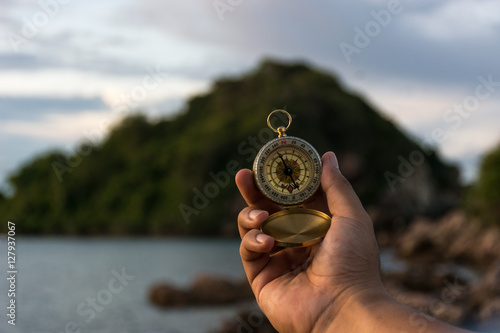 Compass in the hand on the nature background