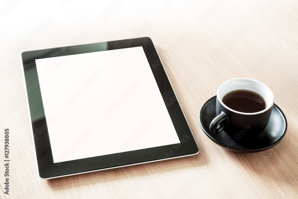 Tablet pc with blank screen on the desk with a cup of coffee Tablet pc with blank screen on the desk with a cup of coffee