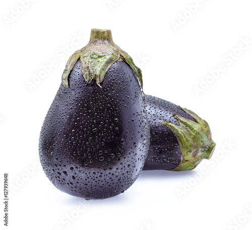 Raw eggplants with water drops on white background.