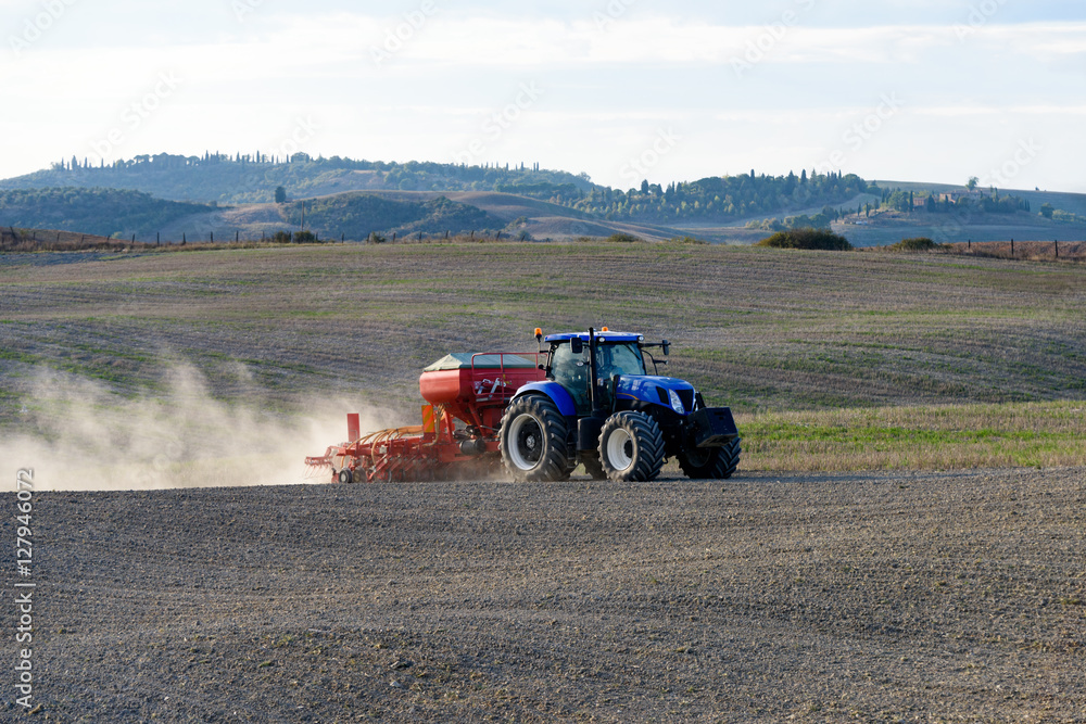 Fototapeta premium Traktor mit Landmaschine zum Vorbereiten des Ackers
