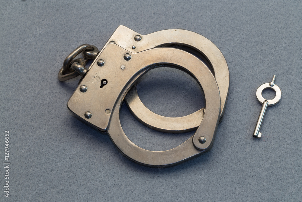 Obraz premium Metal Handcuffs on Gray Background