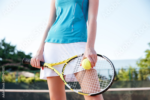 Close up portrait of female legs with tennis racket