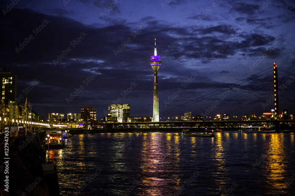 Beleuchtete Rheinkniebrücke in Düsseldorf an einem wolkenverhangenen Herbstabend
