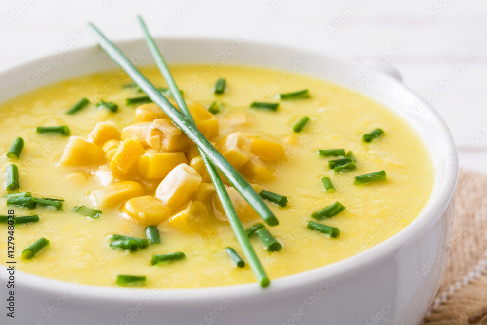Corn soup in white bowl on wooden background.
Corn soup in white bowl on wooden background.