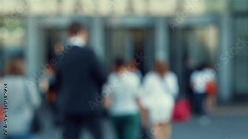 Businessmen crowd near the entry into the business center. People going to work. Concept for finance, job and economy. Modern buildings in business district. Action by day. Focus blur. Toned