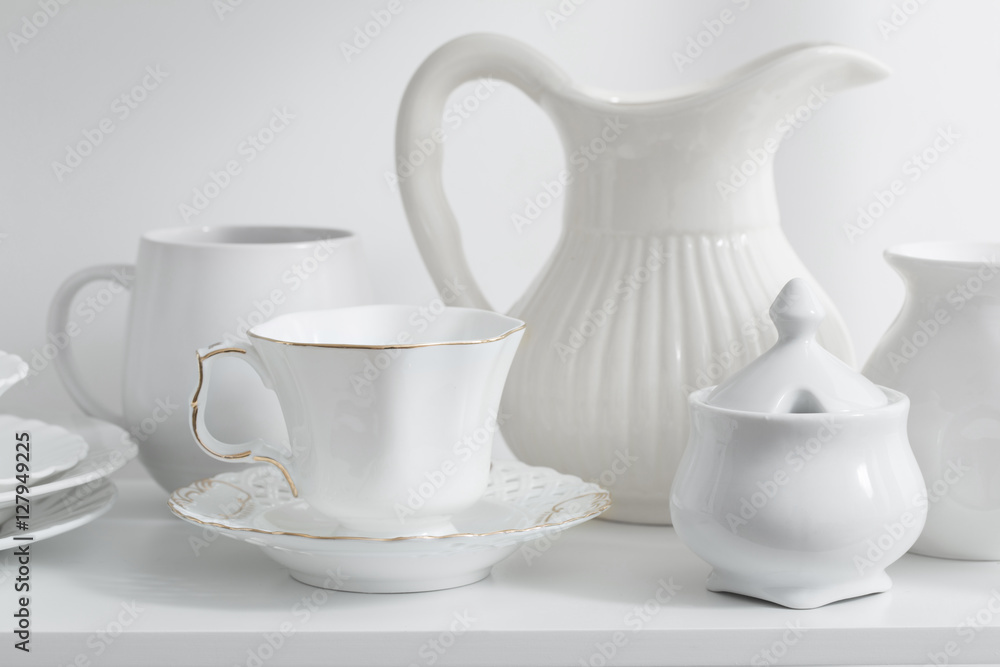 Clean dishes and vases on white wooden shelf Clean dishes and vases on white wooden shelf