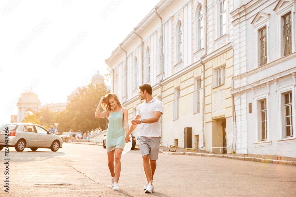 Happy beautiful couple walking on the city street