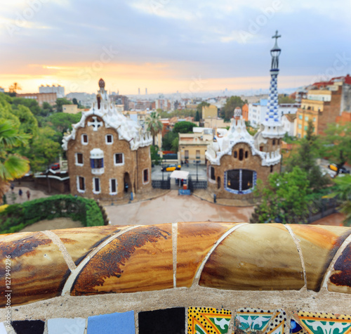 Park Guell in Barcelona. Defocused view to entrace houses with mosaics on foreground