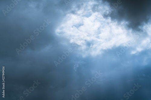 light through clouds - rain producing clouds Light beams penetrate through cloud from sky.
