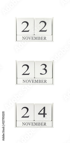 Closeup group of white wooden calendar with black 22 , 23 , 24 november word , three date calendar isolated on white background