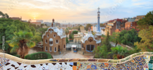 Park Guell in Barcelona. Defocused view to entrace houses with mosaics on foreground