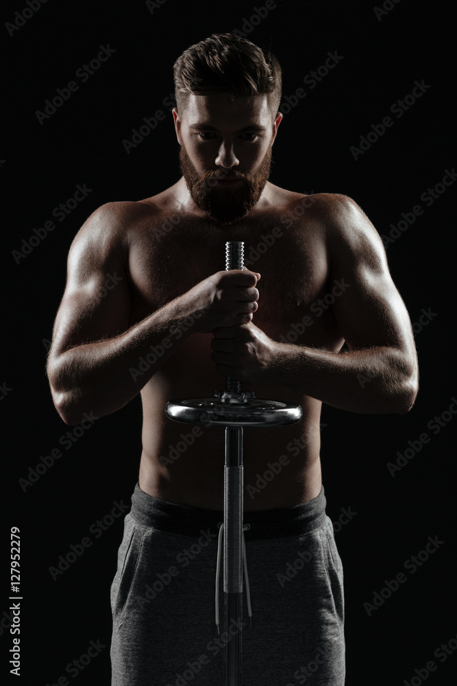 Portrait of naked athletic man with barbell