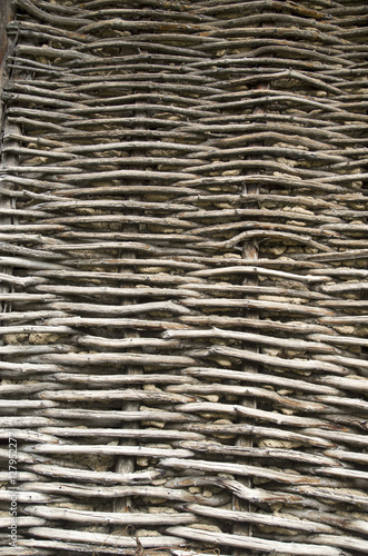 Old wicker wooden wall plastered with mud