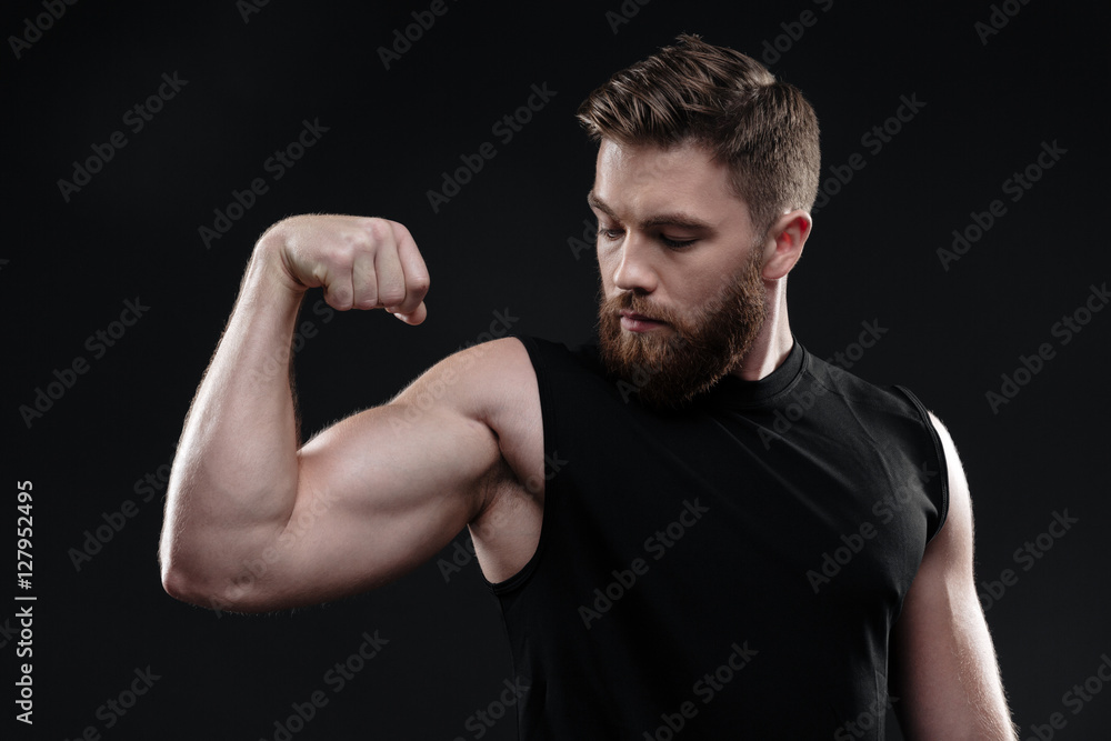 Fitness man demonstrates bicep Fitness man demonstrates bicep