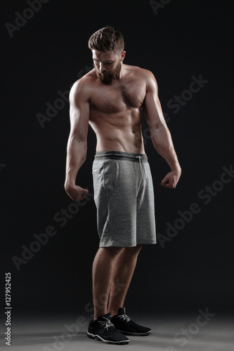 Full length naked muscular man posing