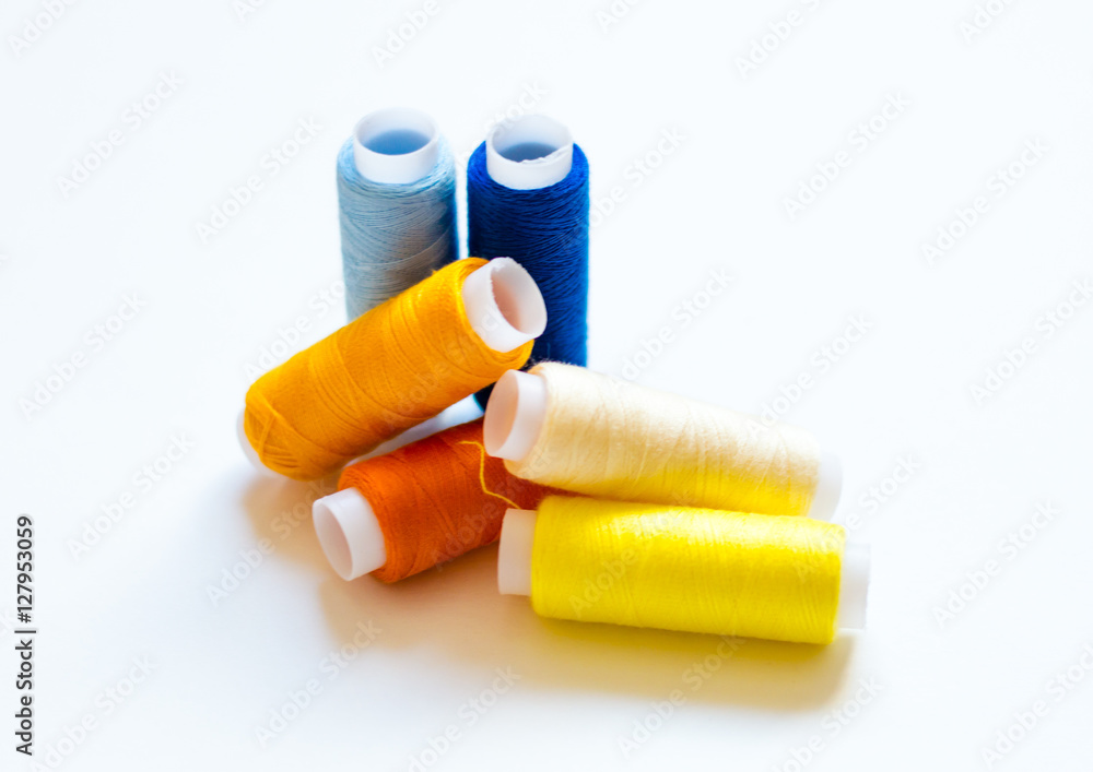 multicolored spools of thread on white background multicolored spools of thread on white background