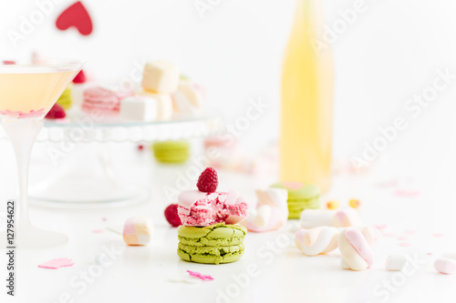 Broken macaroons and berries on table with sweets