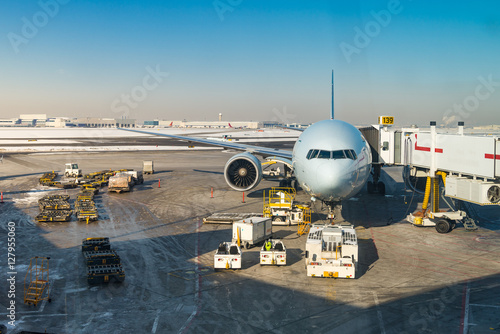 large airliner at gate with ground equipment