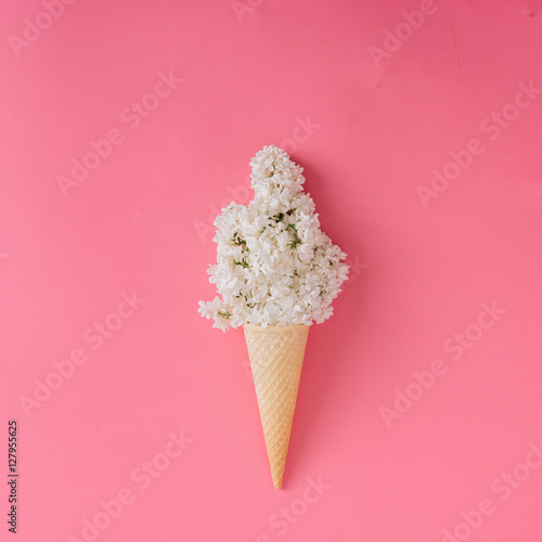 Lilac flower in ice cream cone on pink background.