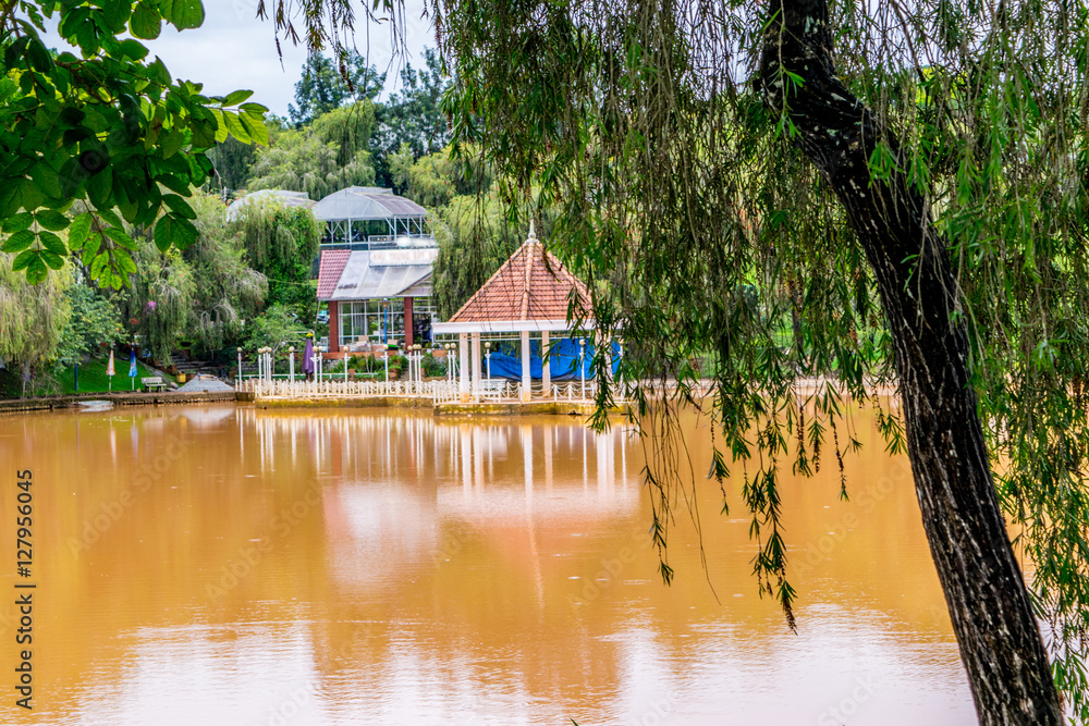 Pond with round pavilion on a water at a park of flowers at Vietnam