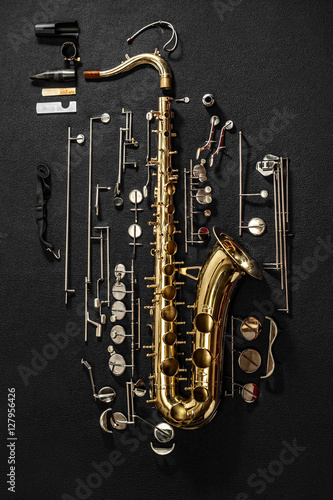Tenor saxophone, exploded view drawing isolated on gray background.
Exploded diagram of tenor saxophone. Key action of instrument.
