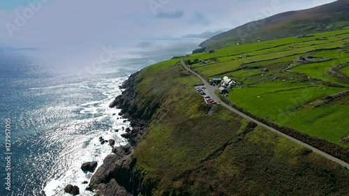 The view of the sea fronting the town of Dingle with a long road on the side of the island in Ireland